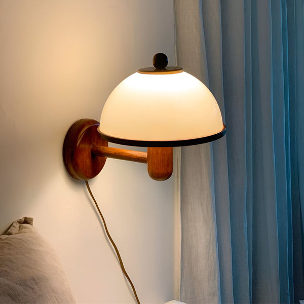 Une image d'une applique murale en bois avec un abat-jour en verre blanc. L'applique est fixée au mur et est dotée d'un cordon d'alimentation. L'abat-jour est en forme de dôme et est fabriqué en verre blanc. L'applique est idéale pour une utilisation dans une chambre à coucher, un salon ou un bureau. WA-9336080733,