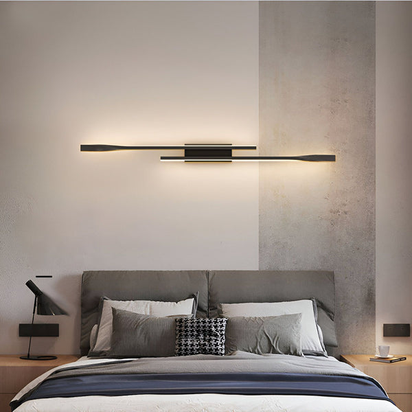 Une image d'une applique et luminaire. L'applique et luminaire est de couleur noire et a une forme rectangulaire. Elle est fixée au mur au-dessus d'un lit. L'applique et luminaire est allumée et émet une lumière blanche. RI-934869958X,RI-2709222655,RI-5156803520,RI-9337067307,