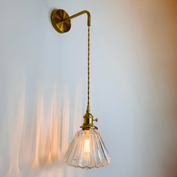 Une applique murale de style baroque avec une finition en laiton. L'applique est dotée d'un abat-jour en verre transparent qui diffuse une lumière douce et tamisée. L'applique est parfaite pour une utilisation dans les chambres à coucher, les salons et les couloirs. SE-3306234591,SE-4665181012,SE-3669452133,