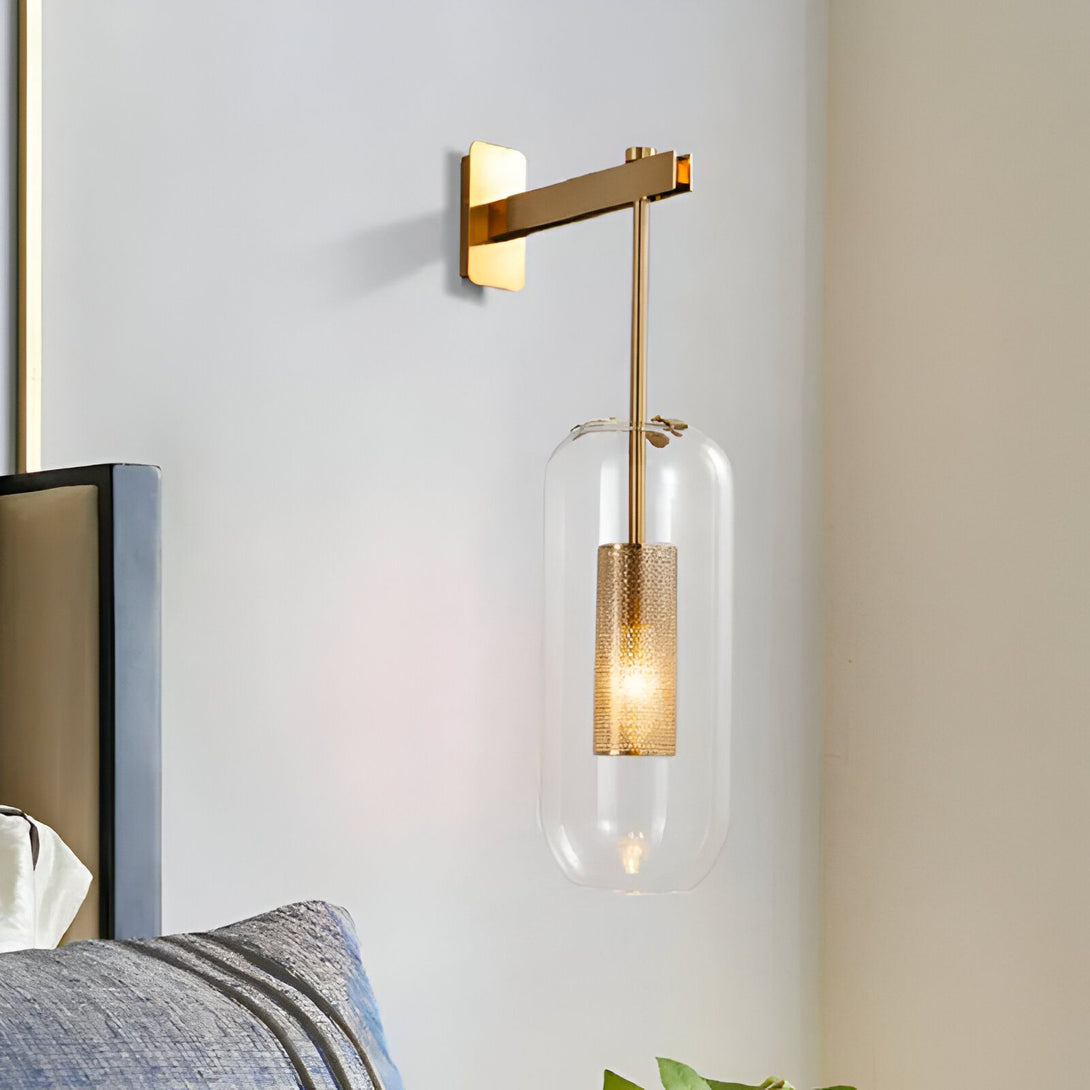 Une applique murale en métal doré avec un abat-jour en verre transparent et un intérieur doré. L'applique est fixée au mur et diffuse une lumière douce et tamisée. DY-3966329891,DY-2145180516,