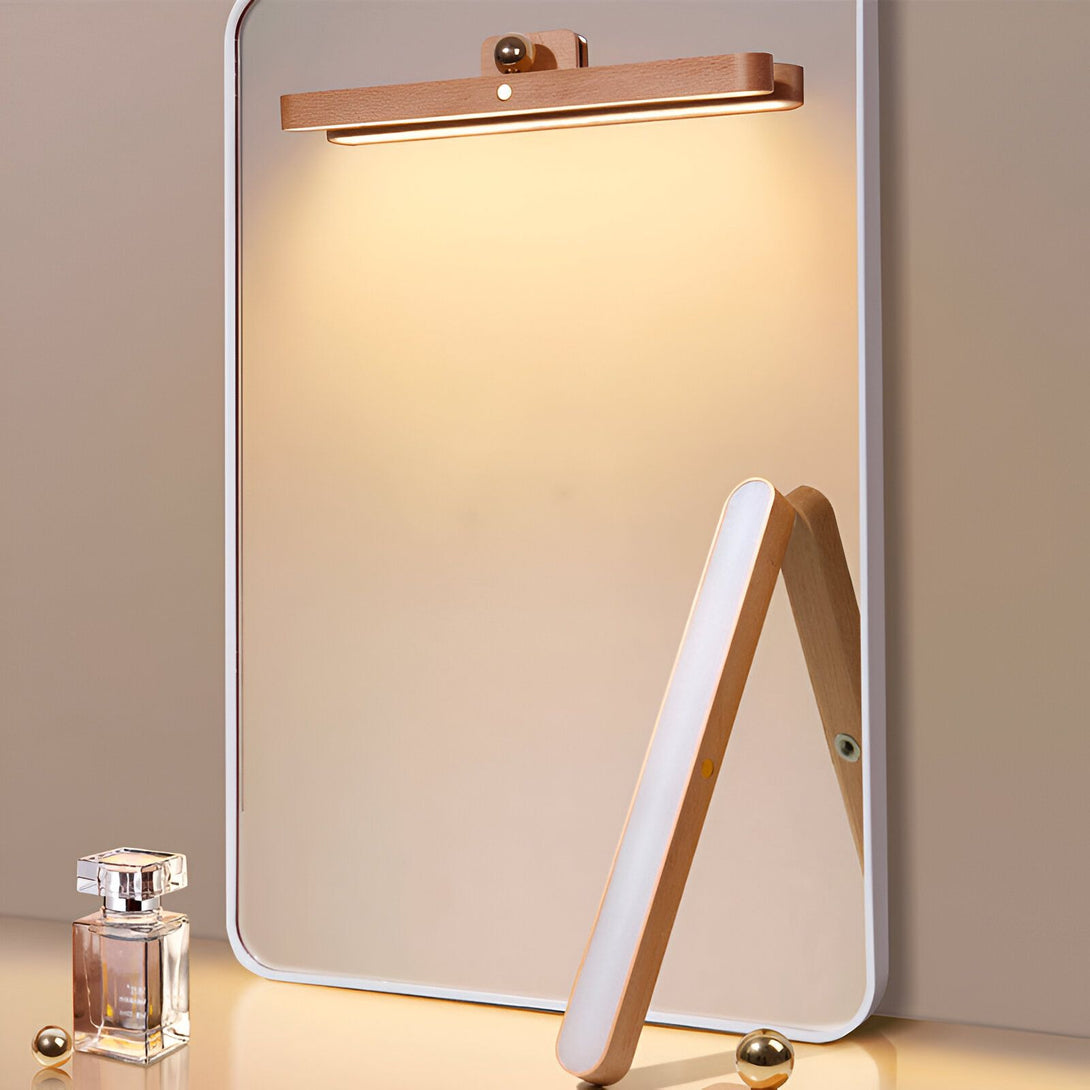 Une lampe de salle de bain en bois avec une lumière blanche brillante. La lampe est fixée au mur au-dessus d'un miroir. Il y a un parfum sur le comptoir. BE-3305924292,