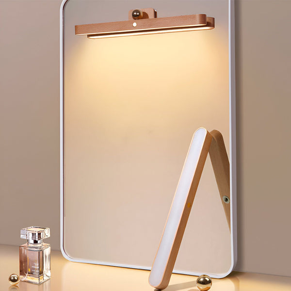 Une lampe de salle de bain en bois avec une lumière blanche brillante. La lampe est fixée au mur au-dessus d'un miroir. Il y a un parfum sur le comptoir. BE-3305924292,