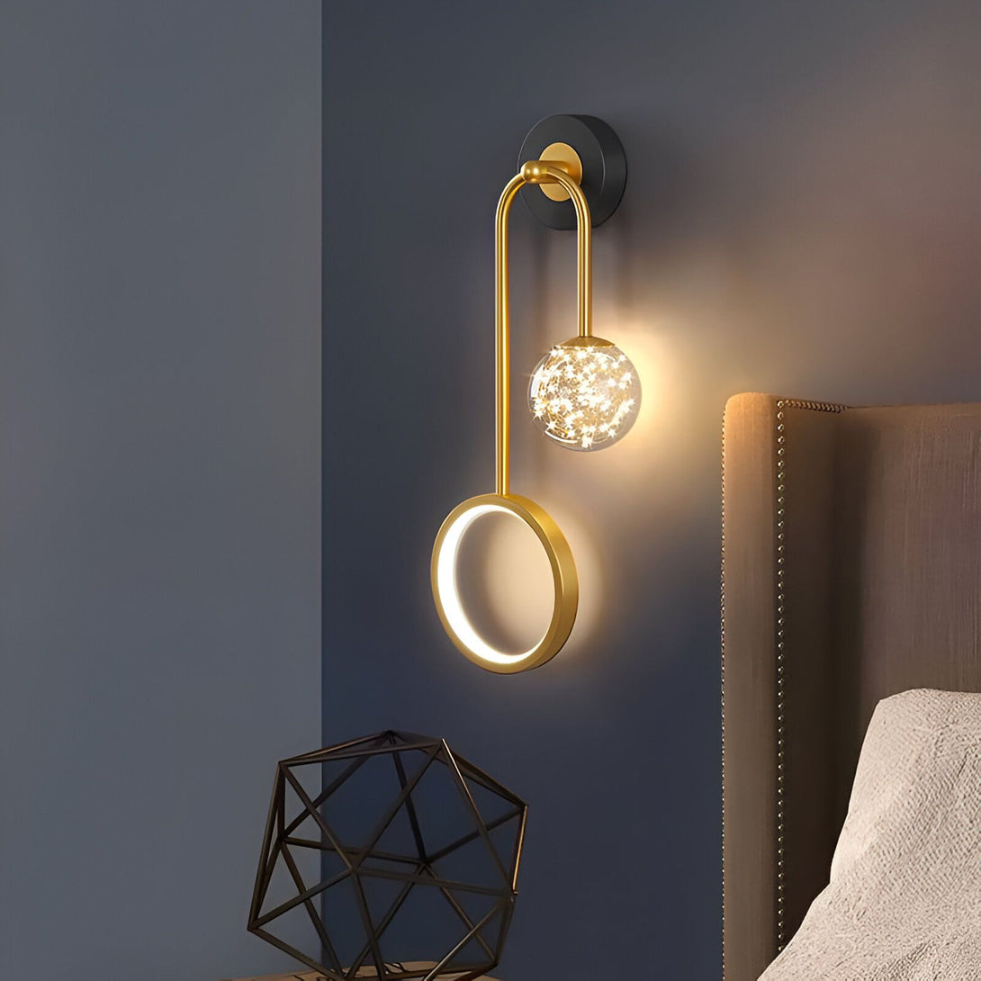 Une applique murale avec une sphère en verre et une forme ronde en métal doré. La sphère est éclairée par des LED et la forme ronde est éclairée par un néon. PE-4825843689,PE-0201404028,PE-1450198899,PE-658010130X,PE-2021905527,PE-6629717953,PE-5793804463,PE-8982774009,PE-4906527779,PE-7249793268,PE-1808265491,PE-1738373908,