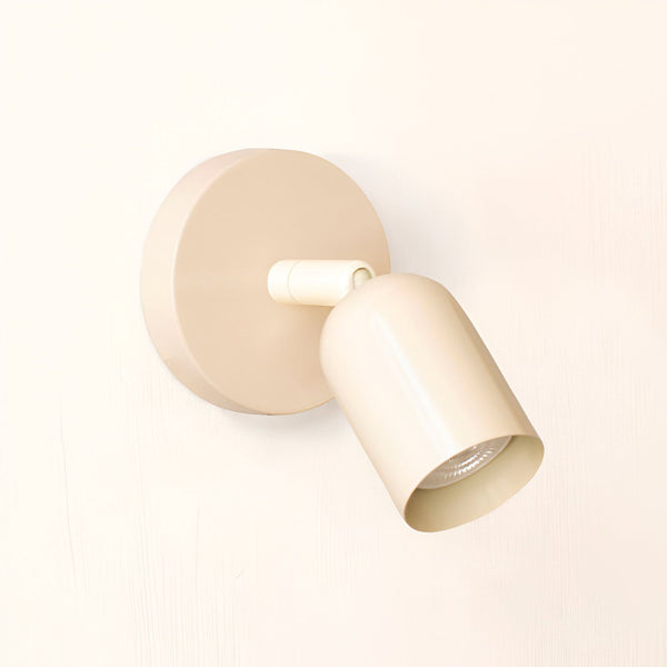 Une image d'une applique murale d'intérieur de couleur beige. L'applique est de forme ronde et possède un abat-jour orientable. Elle est fixée au mur par une platine ronde. L'applique est en métal et possède une finition mate. Elle est équipée d'une douille E14 et est compatible avec les ampoules LED. L'applique est idéale pour éclairer les murs et les objets dans une pièce.
