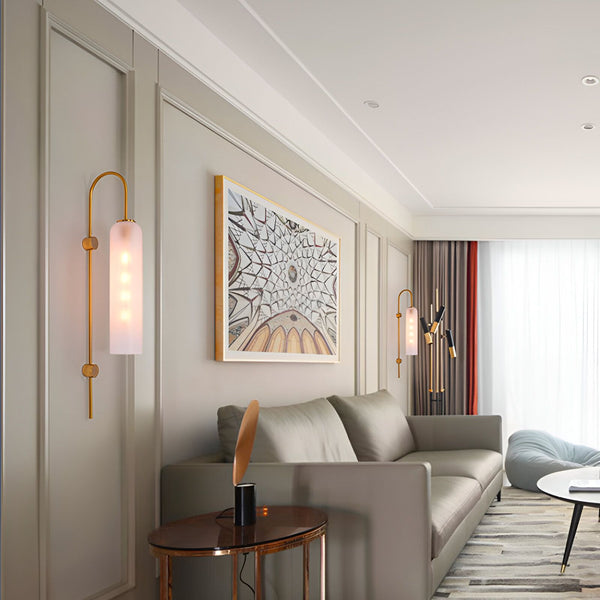 Une image d'un salon avec deux appliques murales en laiton et verre dépoli. Les appliques sont de forme tubulaire et émettent une lumière douce et diffuse. Le salon est décoré dans un style moderne avec des murs gris clair, un canapé beige et des rideaux rouges. OL-7762214003,OL-1185492895,OL-0122222709,OL-6550702720,OL-2563449324,OL-1038284295,OL-6210676383,