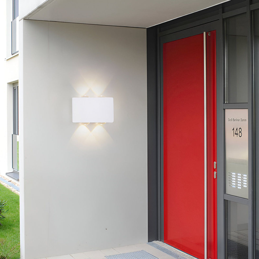 Une applique murale blanche est fixée au mur à côté d'une porte d'entrée rouge. BO-3085302646,BO-7326999600,BO-8165967142,BO-7211273860,BO-9567856427,BO-3084783063,BO-2102062767,BO-9788980031,BO-3357184591,BO-6572328260,BO-0675009294,BO-2785354184,
