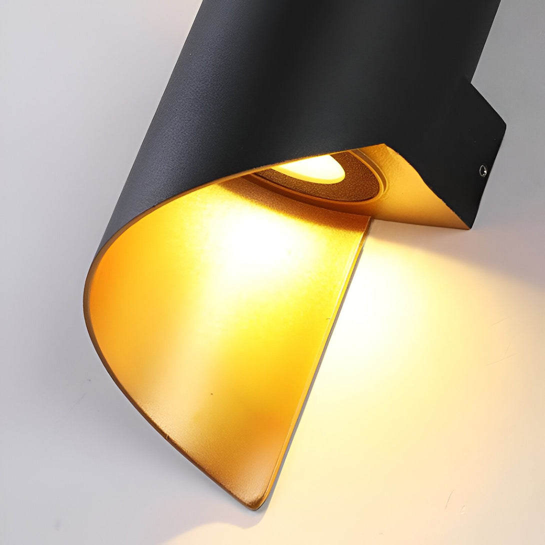 Une applique murale noire avec une lumière LED intégrée. La lumière est orientée vers le bas et projette une lueur dorée sur le mur. LI-469870085X,LI-0368927849,