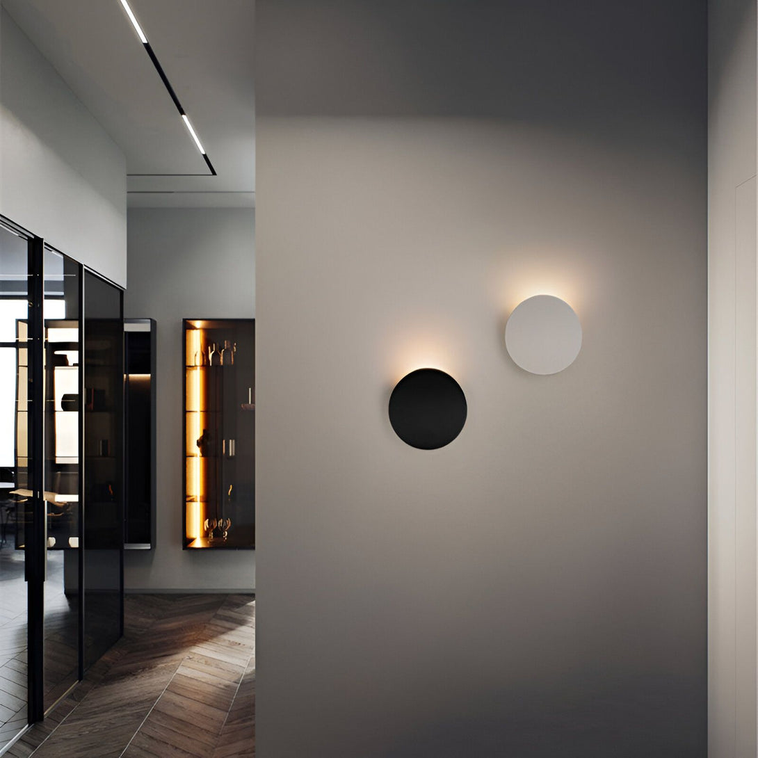 Deux appliques murales rondes, l'une noire et l'autre blanche, sont fixées sur un mur beige. Les appliques émettent une lumière chaude et diffuse. DE-8054556632,DE-0853481989,DE-2502387817,DE-7283470557,DE-6011146961,DE-3639032594,DE-4151317678,DE-0168772612,DE-6626641387,DE-2260219322,DE-6307227001,DE-3738266372,DE-8511010173,DE-7036764996,DE-4587051241,DE-9018460893,DE-0632344601,DE-4256653104,DE-5000257235,DE-4700066563,DE-3834710490,