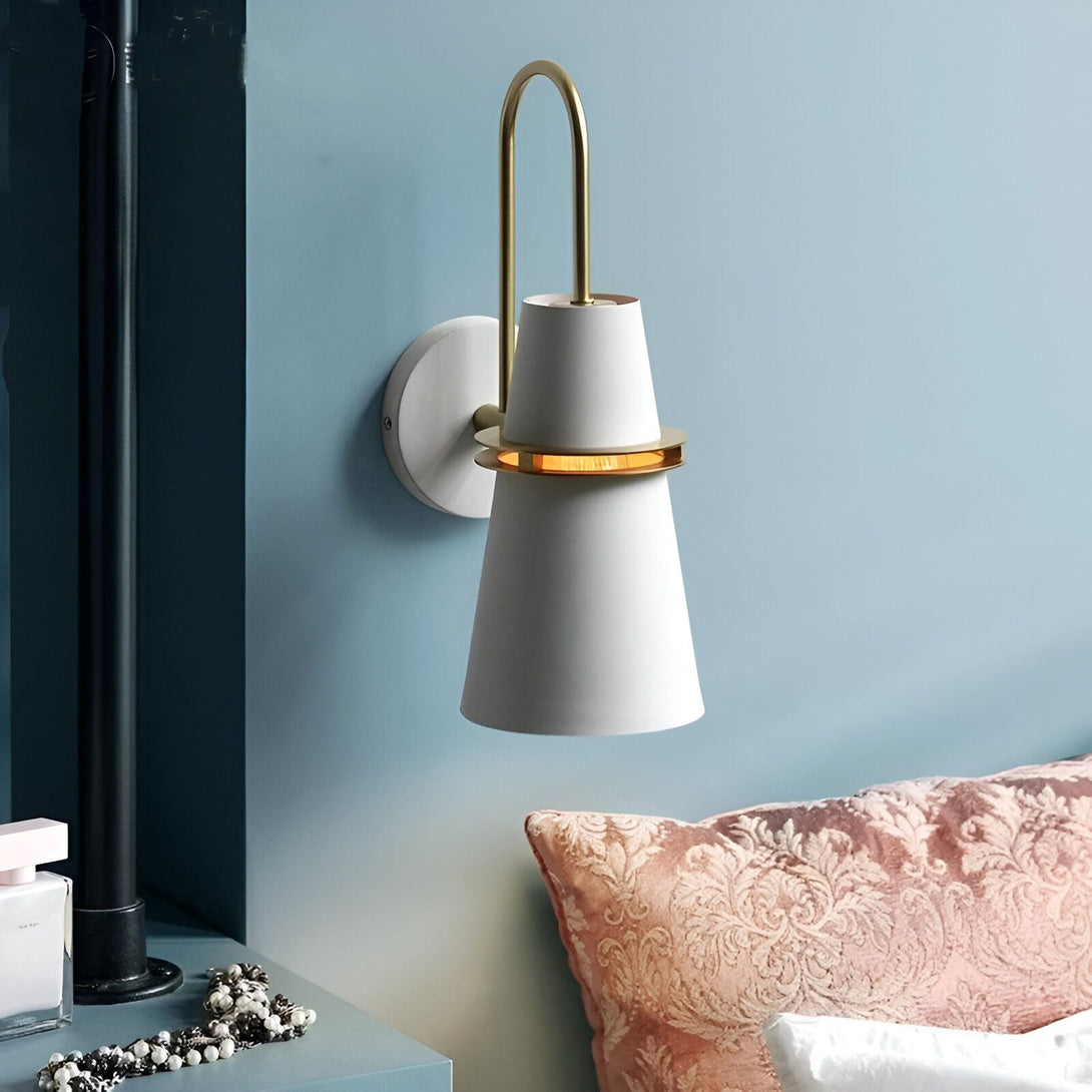 Une applique murale blanche en forme de cône avec un anneau doré. Le mur est bleu et il y a une tête de lit rose à côté. KA-4033461906,KA-553605905X,KA-6540244266,