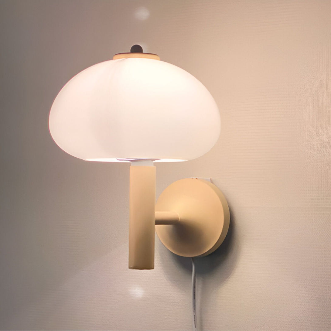 Une image d'une applique murale en forme de champignon. L'abat-jour est en verre blanc et le support est en métal beige. L'applique est fixée au mur par une vis. JA-4181874648,