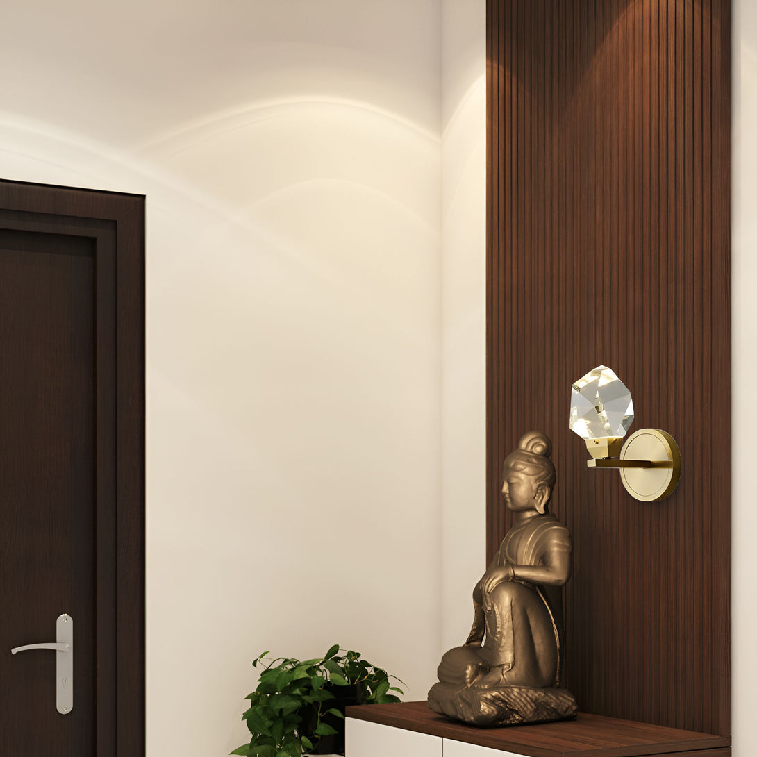 Une image d'un Bouddha assis sur une table en bois. Il y a une applique murale en cristal à côté de lui. La porte en bois est ouverte et il y a un mur en bois avec des rainures verticales à côté de la porte. OP-5554030025,OP-6981510057,