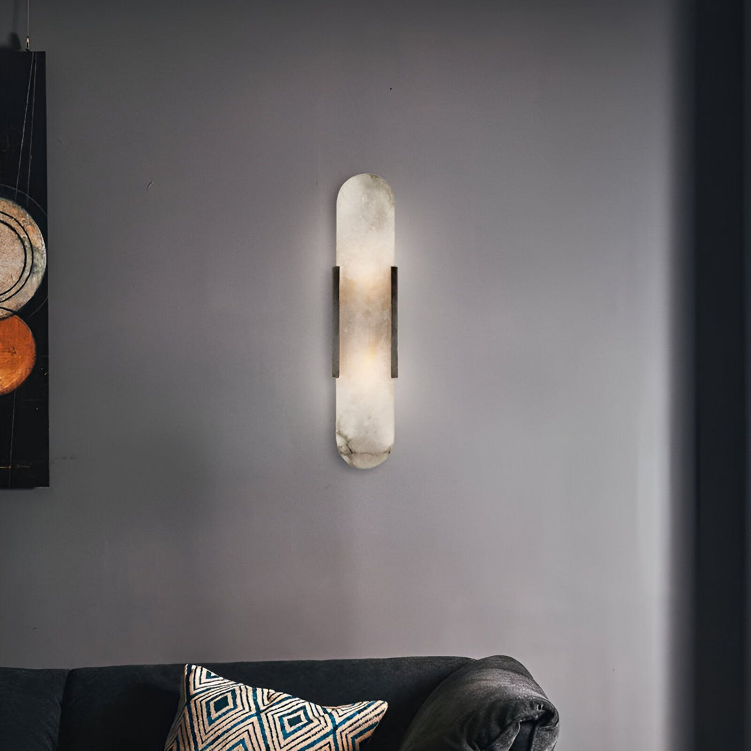 Une applique murale en albâtre. L'applique est de forme rectangulaire et est fixée au mur par deux supports en métal noir. La lumière est diffusée par la tranche de l'albâtre. FU-8330655202,FU-7846624369,FU-6574596262,FU-5000429826,