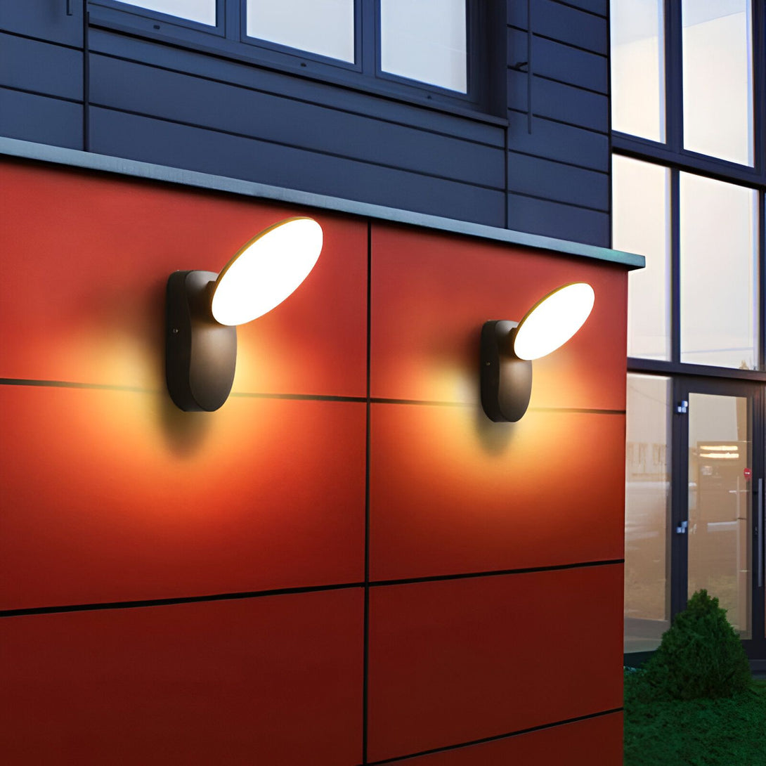 Une image d'une applique murale extérieure étanche. L'applique est de couleur noire et a une forme ovale. Elle est fixée au mur par deux vis. L'applique est éclairée par une lumière LED blanche. LI-7997035176,LI-6815012948,
