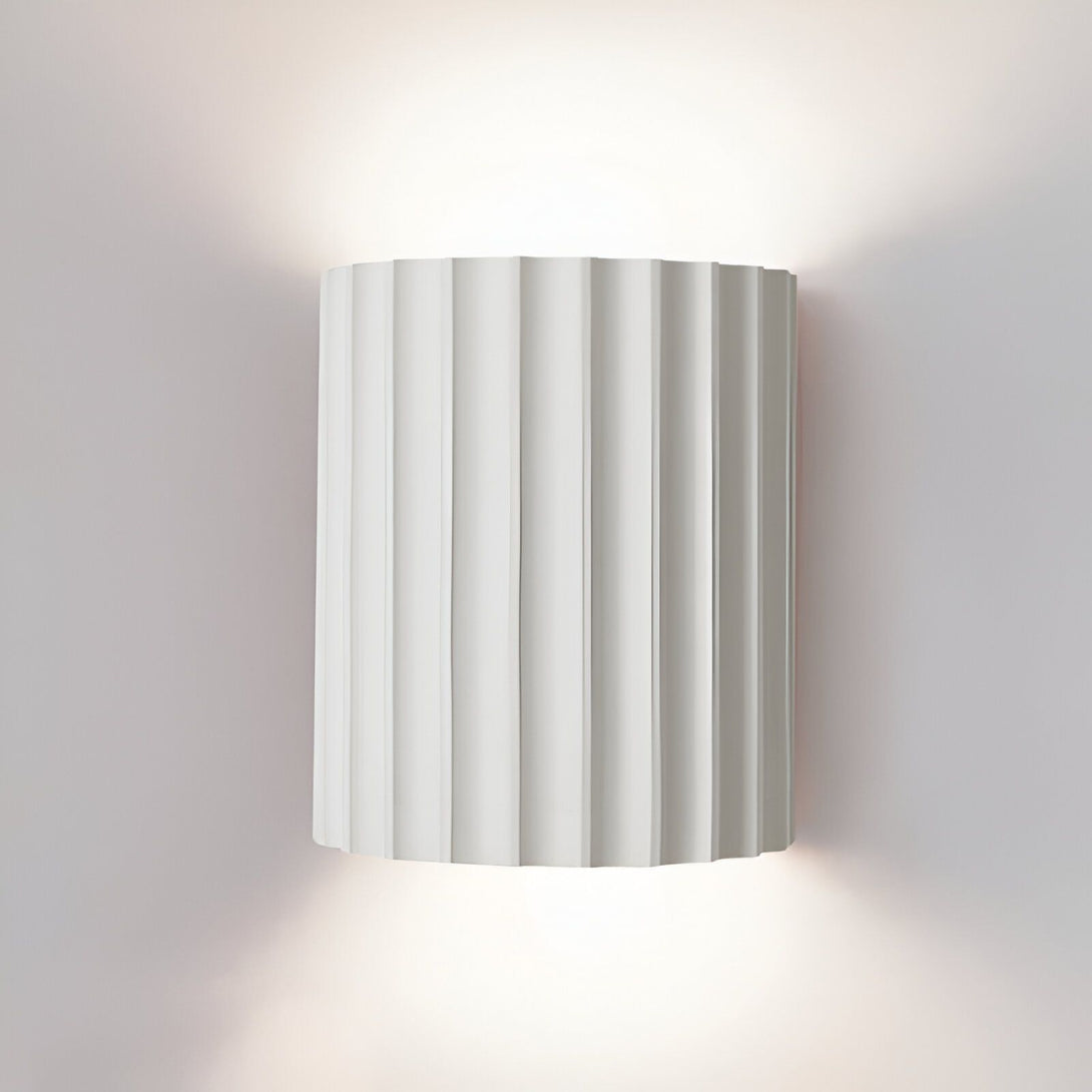 Une applique murale blanche en forme de colonne grecque diffuse une lumière douce et tamisée. BE-6850514202,BE-3382789000,BE-7444756163,BE-613585335X,