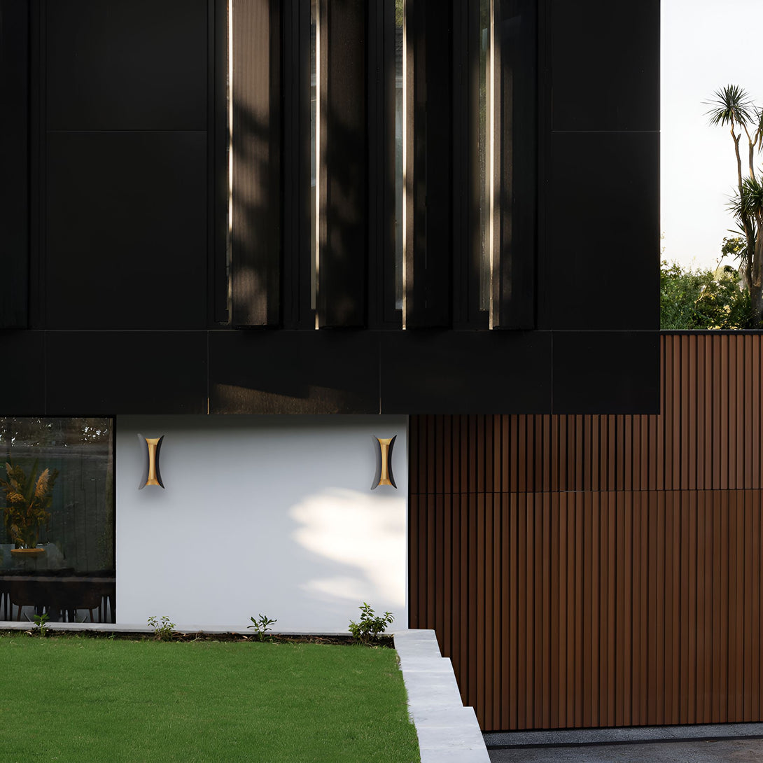 Une image d'une maison moderne avec une façade noire et des murs blancs. Il y a une porte de garage en bois et des fenêtres noires. La maison est entourée d'herbe verte et de plantes. AV-8032383352,