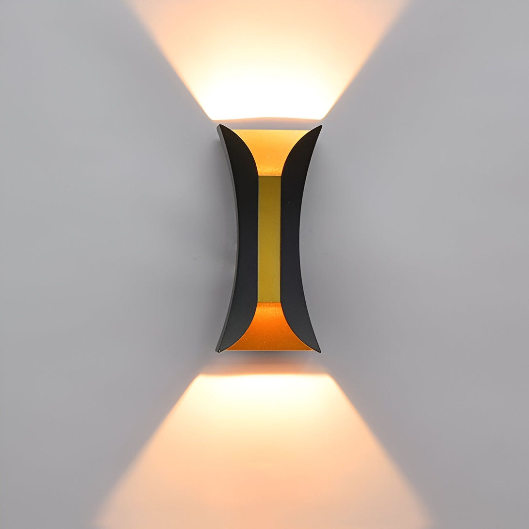 Une applique murale noire et dorée en forme de I. La lumière est allumée et projette deux faisceaux lumineux sur le mur. AV-8032383352,