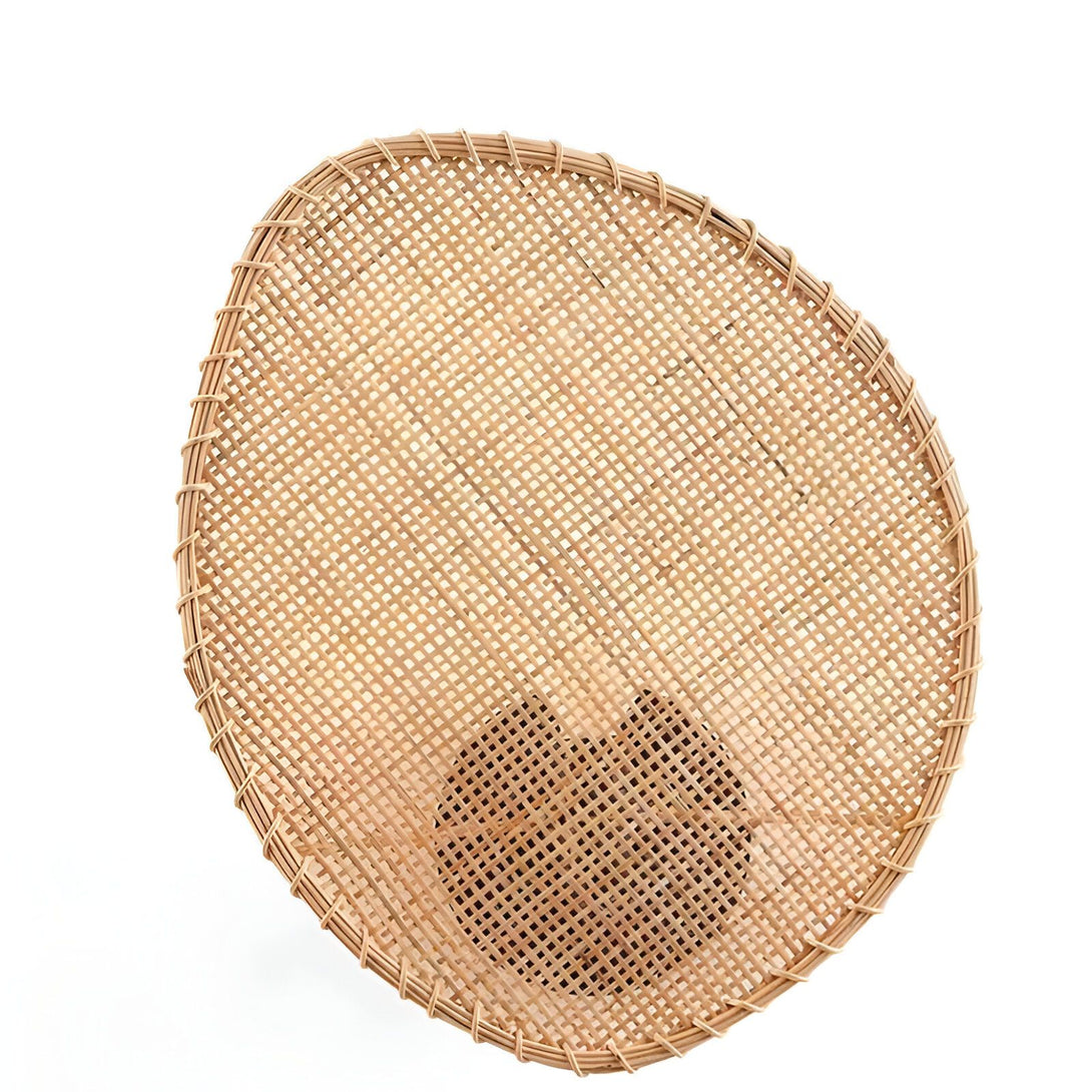 Un panier rond en osier tressé de couleur marron clair avec un trou au milieu sur fond blanc EN-7337637519,EN-7543142791,