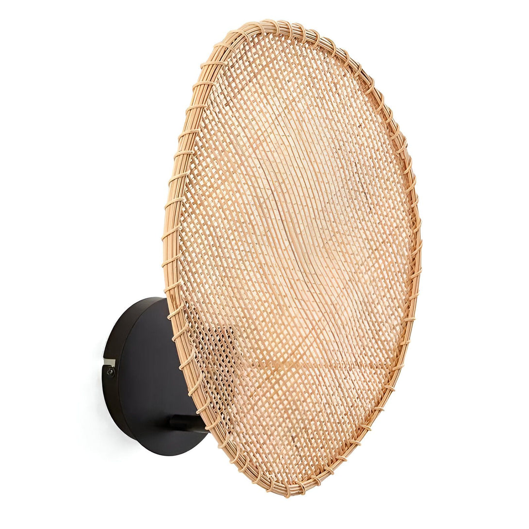 Une applique murale en rotin tressé de forme ronde avec un fond noir. EN-7337637519,EN-7543142791,