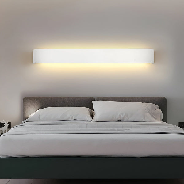 Une image d'une applique murale LED blanche de forme rectangulaire. L'applique est fixée au mur au-dessus d'un lit. La lumière est allumée et diffuse une lumière blanche chaude. AL-1403436983,AL-0024826731,AL-5447236630,
