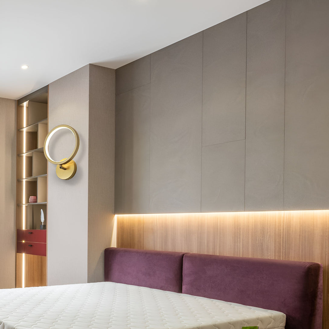 Une chambre avec un lit, une armoire et une applique murale ronde et dorée. EL-3769676734,EL-0921071280,EL-2038712905,