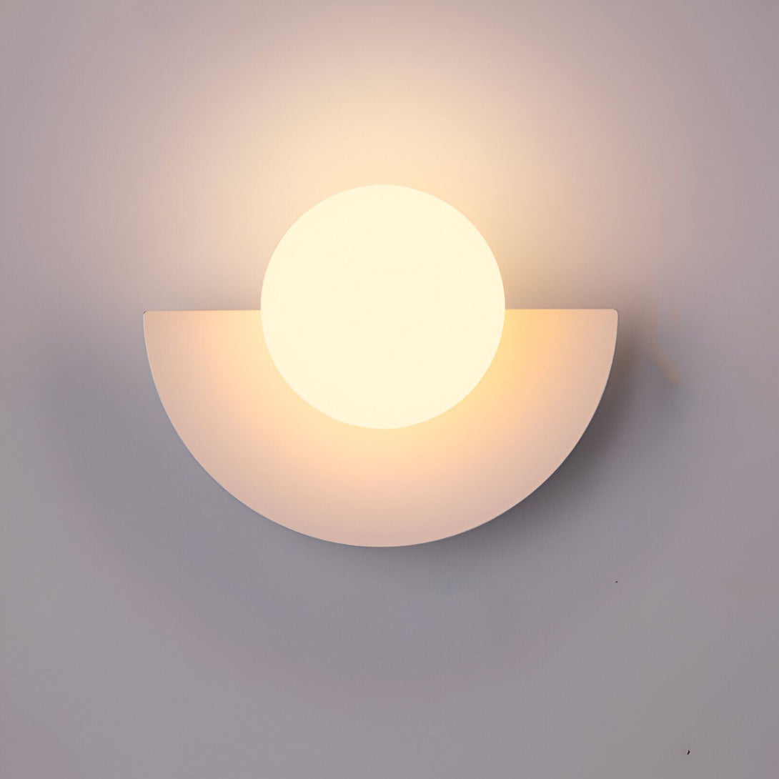 Une applique murale blanche en forme de demi-lune avec une boule en verre opalin qui diffuse une lumière douce et chaleureuse. GU-5717952775,GU-9785984192,GU-5756525742,GU-2770483412,GU-259462313X,GU-7909977727,GU-9845973795,GU-8738437147,GU-6622229414,GU-8570558481,GU-3445094918,GU-3069247571,GU-5711512889,GU-8453761582,GU-7173945844,