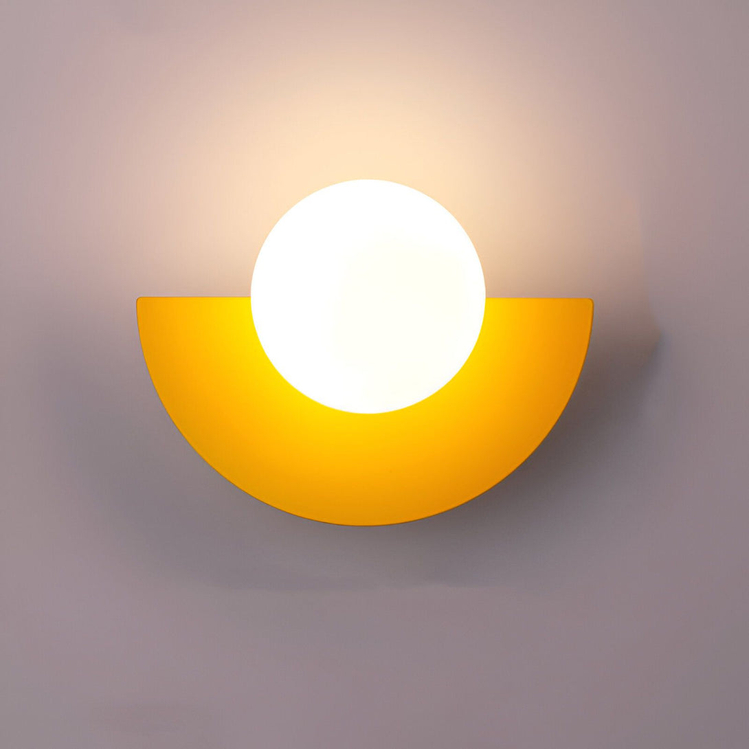Une applique murale en forme de demi-lune jaune avec une boule en verre blanc. GU-5717952775,GU-9785984192,GU-5756525742,GU-2770483412,GU-259462313X,GU-7909977727,GU-9845973795,GU-8738437147,GU-6622229414,GU-8570558481,GU-3445094918,GU-3069247571,GU-5711512889,GU-8453761582,GU-7173945844,