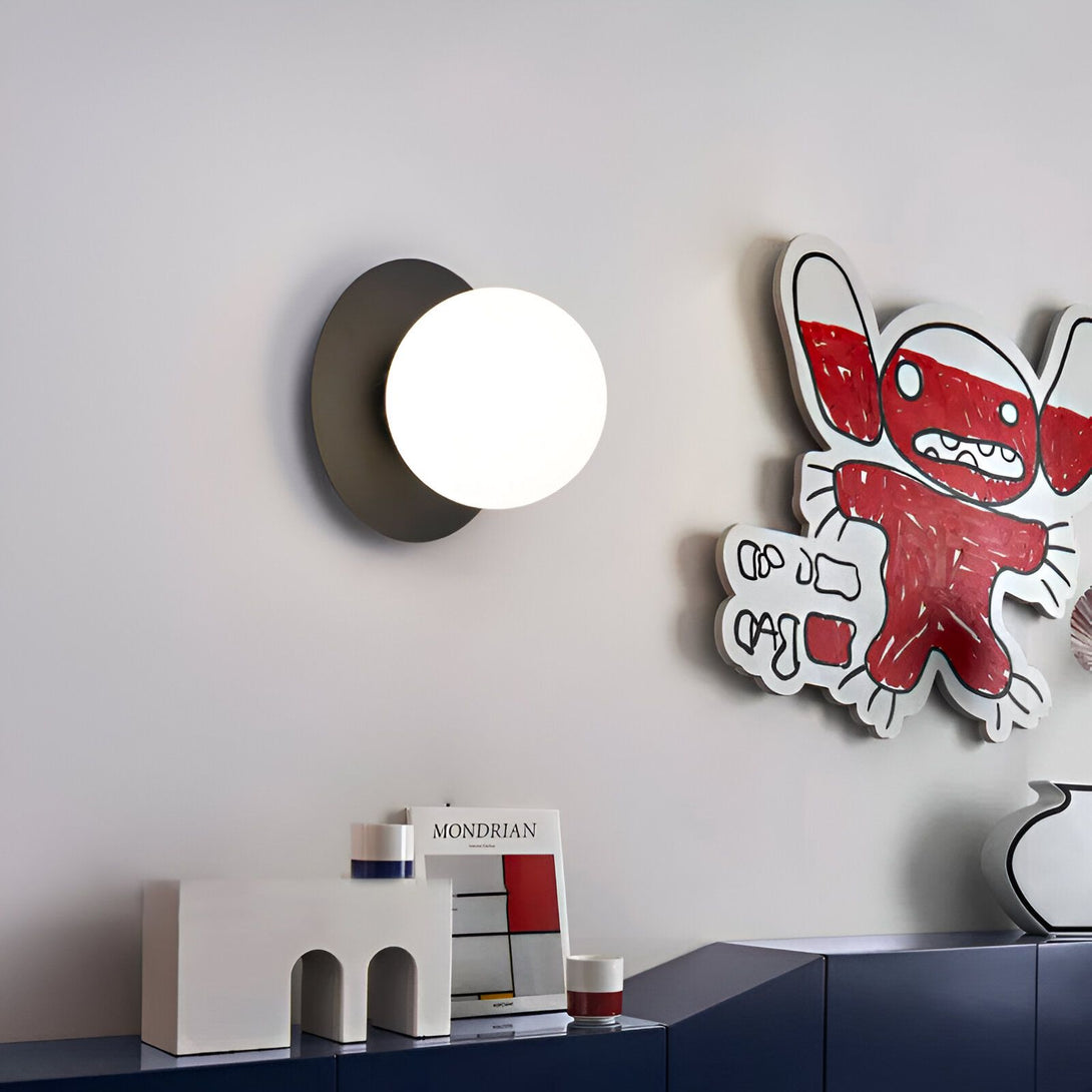 Une image d'une applique murale blanche et noire avec une forme ronde. À côté, il y a une illustration colorée représentant un monstre. KE-2275189483,KE-5558580682,KE-7081243789,KE-0448745380,