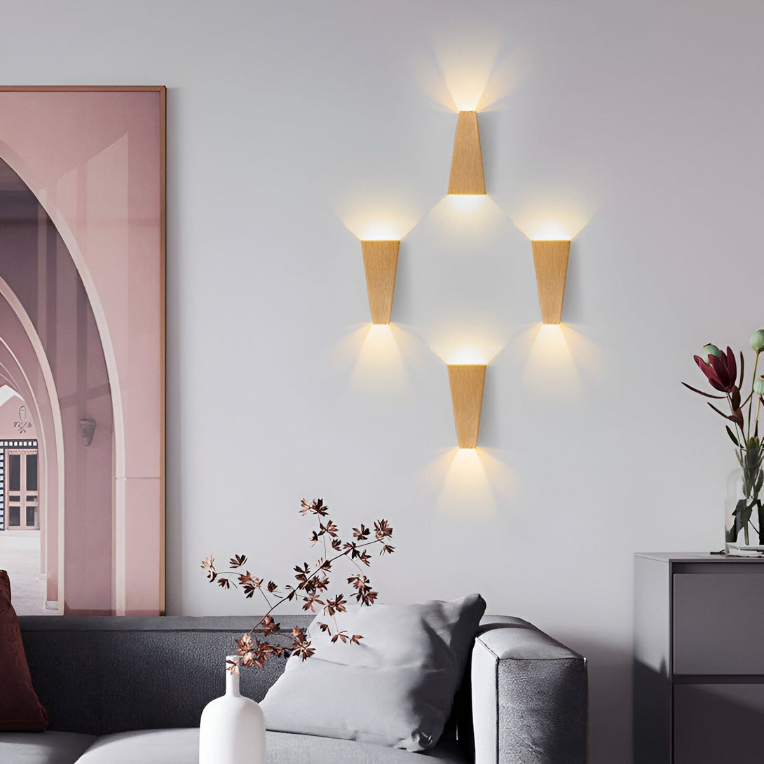 Une image d'un salon avec des murs blancs et un canapé gris. Il y a six appliques murales en bois disposées en triangle au-dessus du canapé. Il y a aussi un vase avec des fleurs séchées sur la table basse. LE-6923734606,LE-2364176867,LE-5760761307,LE-4077350220,LE-2235620051,LE-9830597490,