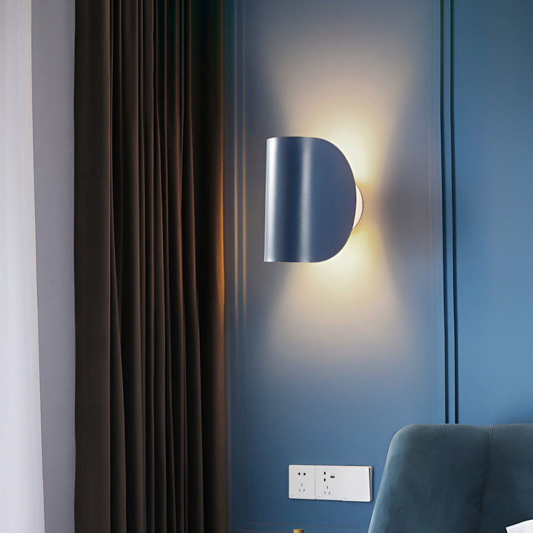 Une applique murale en métal bleu avec une forme demi-lune est fixée au mur bleu foncé. À côté, se trouve une tenture de couleur marron. LA-3498052438,LA-3126612202,LA-0767634896,LA-9110294503,LA-9304635144,LA-992136202X,LA-6928936177,LA-4294847212,LA-0743361954,LA-9969297945,LA-912855230X,LA-8850209142,