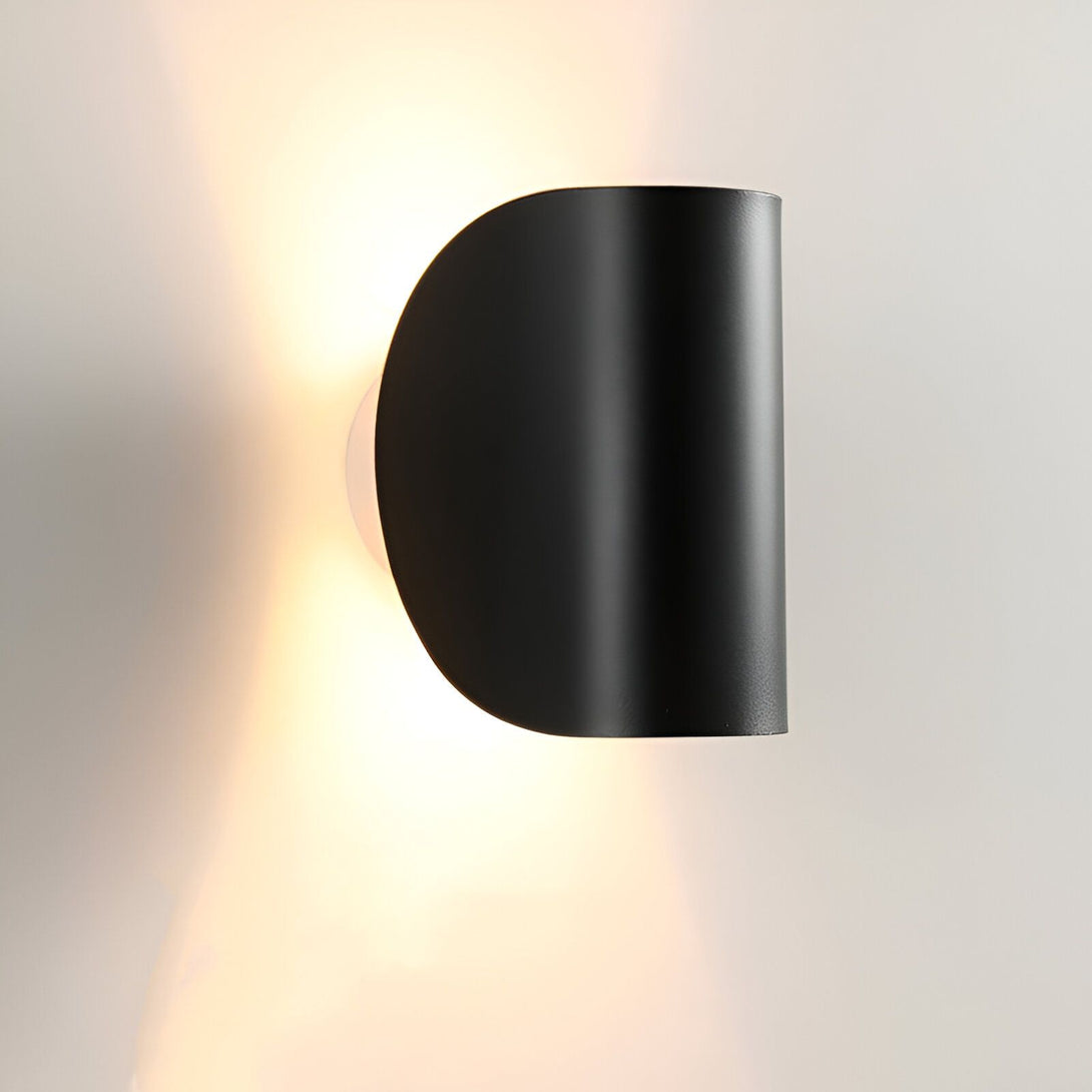Une applique murale noire en forme de demi-lune émet une lumière chaude. LA-3498052438,LA-3126612202,LA-0767634896,LA-9110294503,LA-9304635144,LA-992136202X,LA-6928936177,LA-4294847212,LA-0743361954,LA-9969297945,LA-912855230X,LA-8850209142,