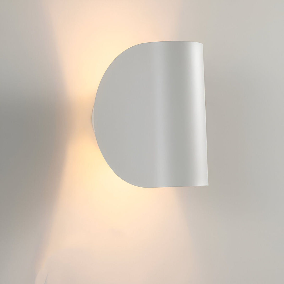 Une applique murale blanche en forme de demi-lune émet une lumière chaude sur un mur blanc. LA-3498052438,LA-3126612202,LA-0767634896,LA-9110294503,LA-9304635144,LA-992136202X,LA-6928936177,LA-4294847212,LA-0743361954,LA-9969297945,LA-912855230X,LA-8850209142,