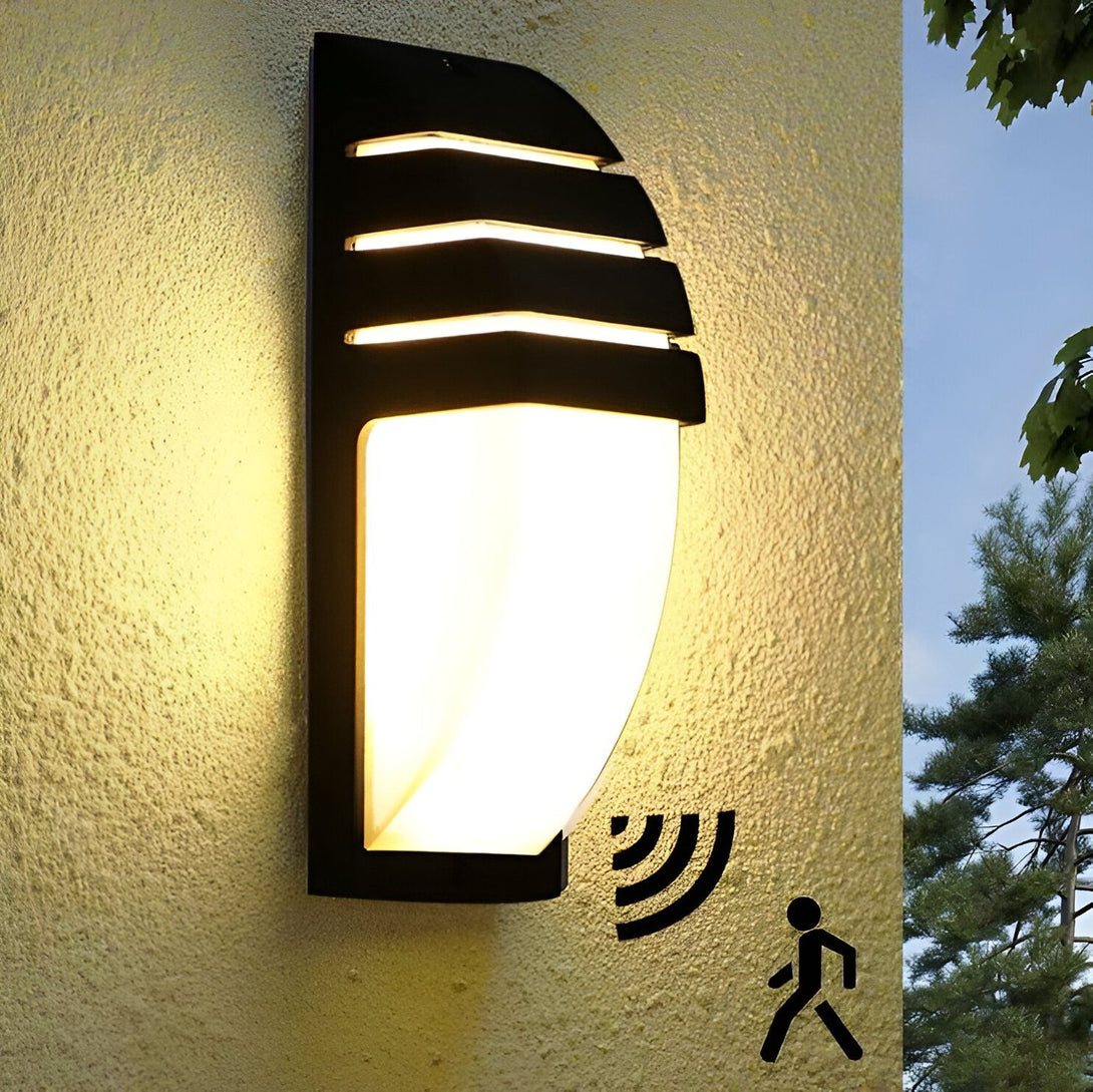 Une applique murale extérieure avec un détecteur de mouvement. L'applique est noire et a une forme rectangulaire. Le détecteur de mouvement est situé en bas de l'applique. LO-5223225813,