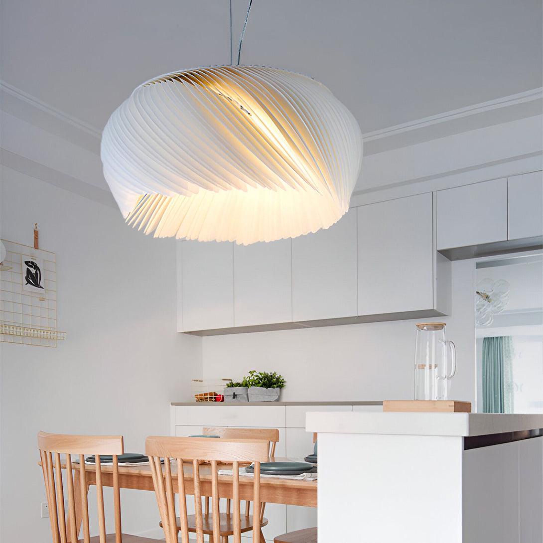 Une image d'une suspension design en forme de spirale blanche. La suspension est accrochée au plafond et éclaire la table à manger en dessous. La table est en bois et les chaises sont en bois et rembourrées de tissu beige. Il y a un tapis sous la table. La pièce est lumineuse et a des murs blancs. LI-2975946449,LI-0269909052,LI-3785723539,LI-9818085345,