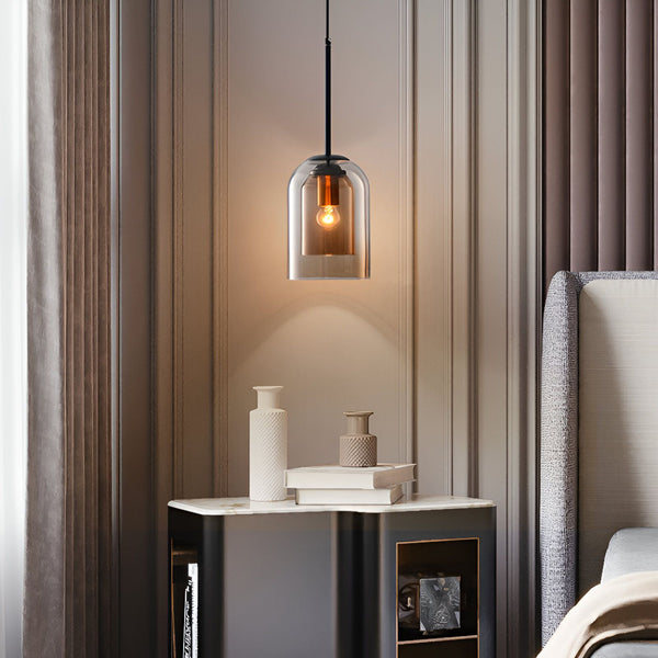 Une suspension en verre de couleur cognac et de forme cloche. La suspension est dotée d'un câble noir et d'une douille E14. Elle est idéale pour une utilisation en intérieur et est facile à installer. VA-1821147340,VA-4740185229,