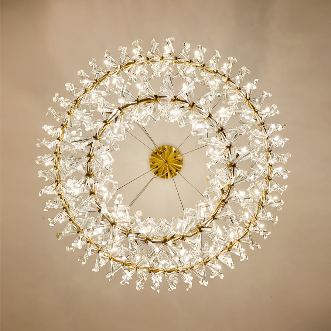 Un lustre rond en cristal avec des branches en forme de fleurs. Il est doré et éclairé. EK-1487295170,EK-2785100514,EK-4427580491,EK-6790730826,