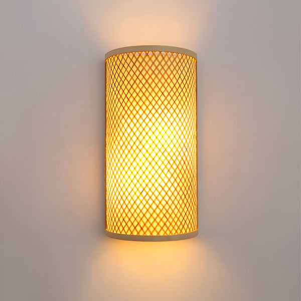 Une applique murale en bambou ajouré de forme cylindrique émettant une lumière tamisée. DE-7247857110,