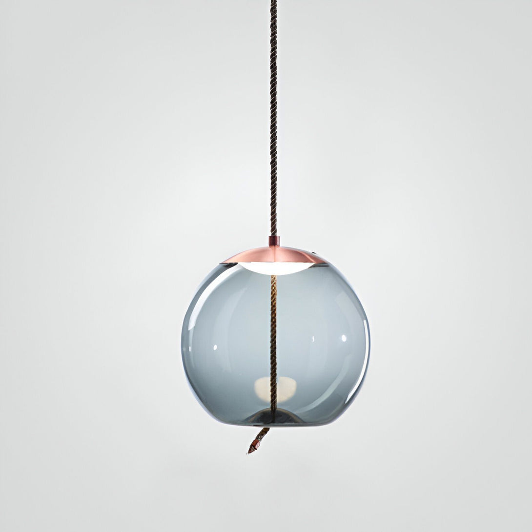 Une image d'un globe en verre soufflé à la main avec une monture en cuivre. Le globe en verre est de couleur gris fumé et la monture en cuivre est de couleur cuivre. Le globe en verre est suspendu à un cordon en cuir marron. SE-8597680784,SE-9462870446,SE-7499298493,SE-0476608740,SE-2722836270,SE-3273417943,SE-5200325382,SE-3888024714,