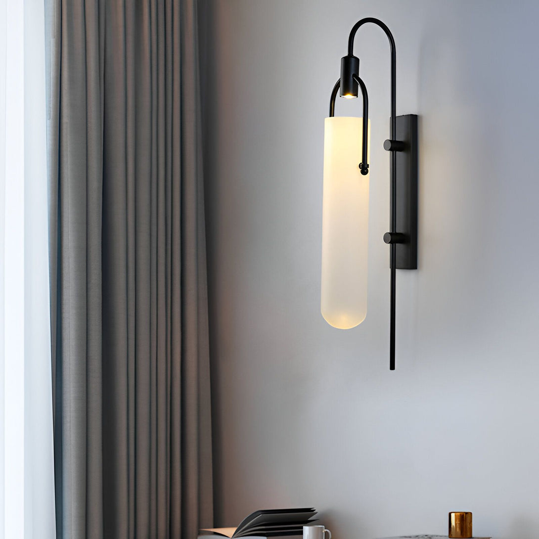 Une applique murale en verre dépoli avec une finition noire. L'applique est fixée au mur par un bras en métal noir. L'ampoule est située à l'intérieur du tube en verre dépoli. L'applique est allumée et émet une lumière douce et diffuse. ES-2484930887,ES-5612768230,ES-0022150080,ES-6055592797,ES-8057480351,ES-6019174972,ES-947368861X,ES-3587232709,