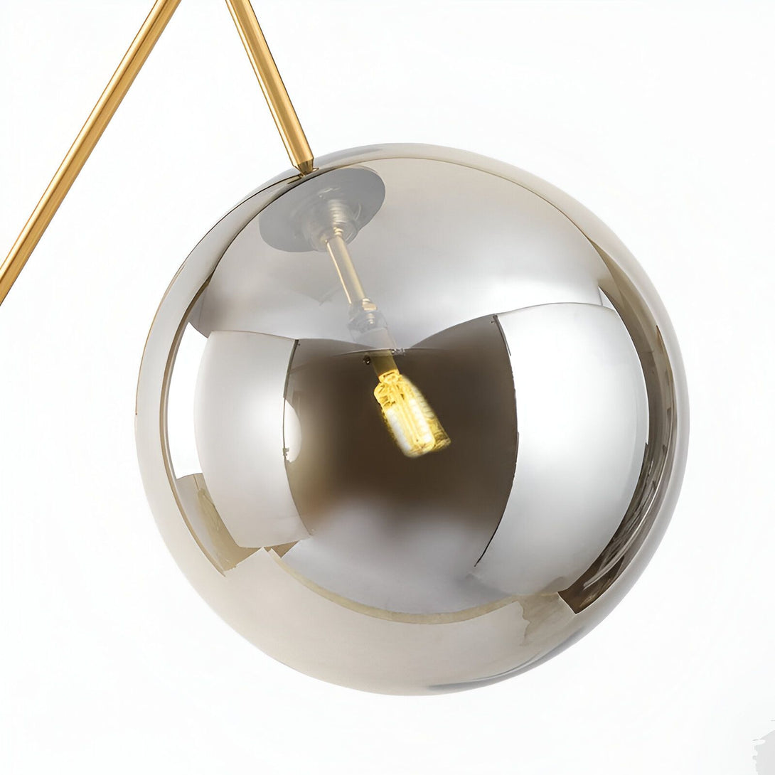 Une image d'une sphère en verre transparent avec une lumière à l'intérieur. La sphère est suspendue par un fil doré. MA-3942036177,MA-3064936387,