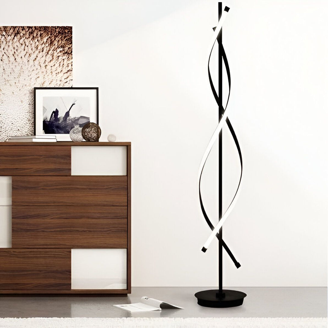 Un lampadaire noir avec une forme torsadée et une lumière blanche. Il est placé à côté d'un meuble en bois et d'un tapis beige. LS-3164174144,LS-6358658263,
