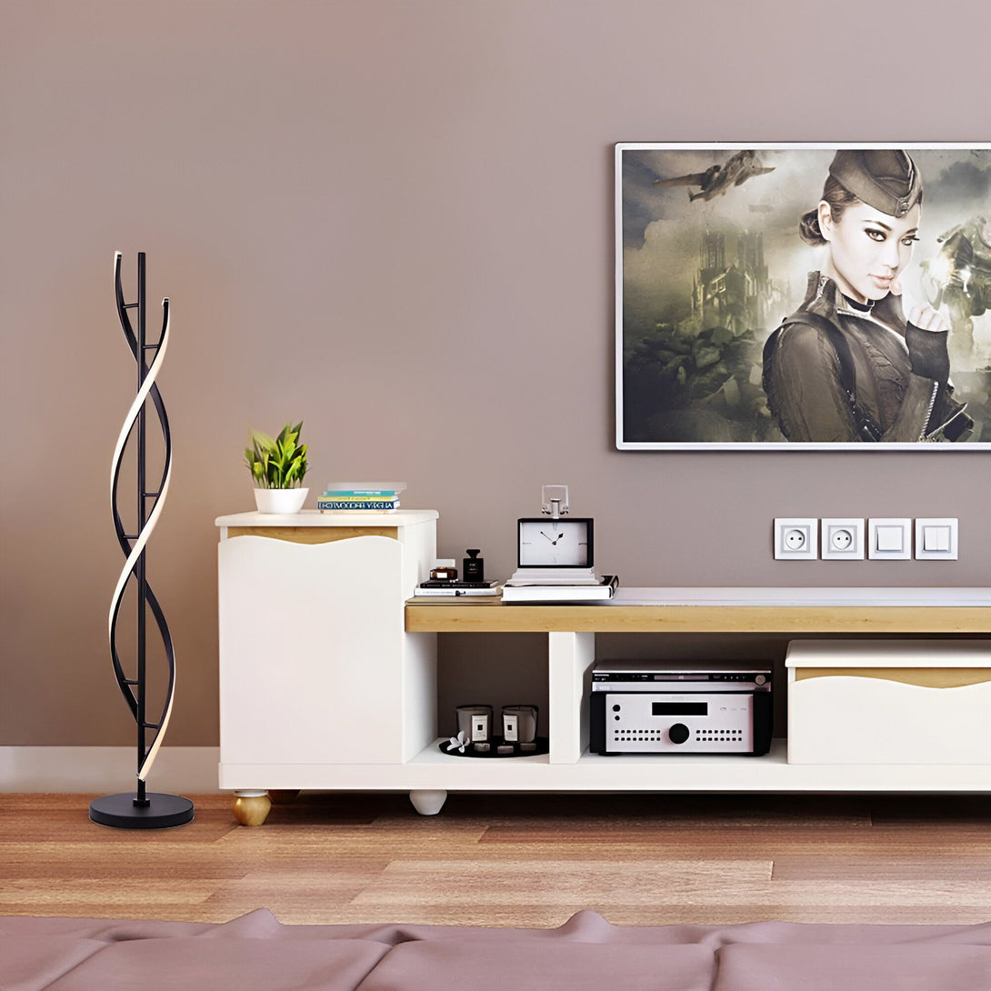 Un lampadaire noir et blanc en forme de spirale est placé à côté d'un meuble TV blanc. Sur le meuble TV, il y a une plante verte, des livres, un parfum et une horloge. Au-dessus du meuble TV, il y a une télévision qui diffuse une image d'une femme soldat. LS-3164174144,LS-6358658263,