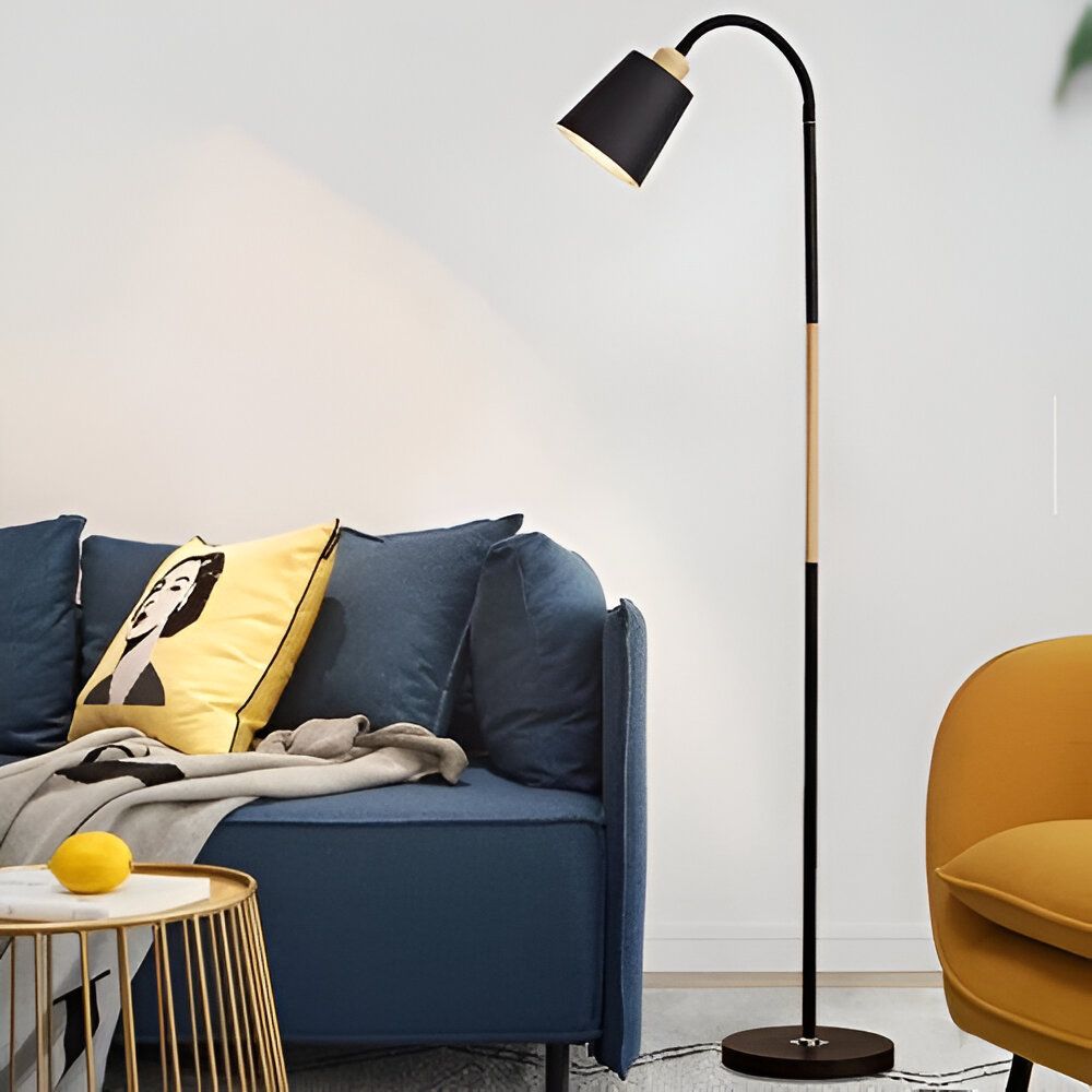 lampadaire scandinave en acier et bois. Il est de couleur noire et possède un abat-jour en métal. Le lampadaire est posé sur un trépied en bois. Il est parfait pour éclairer un salon ou une chambre à coucher. SV-6826327228,SV-1292325151,