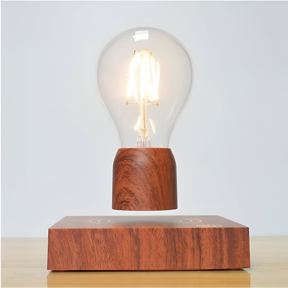 Une lampe de chevet en bois avec une ampoule qui flotte au-dessus d'un socle en bois. L'ampoule est maintenue en l'air par un champ magnétique. La lampe est alimentée par un câble USB. AL-5617346911,