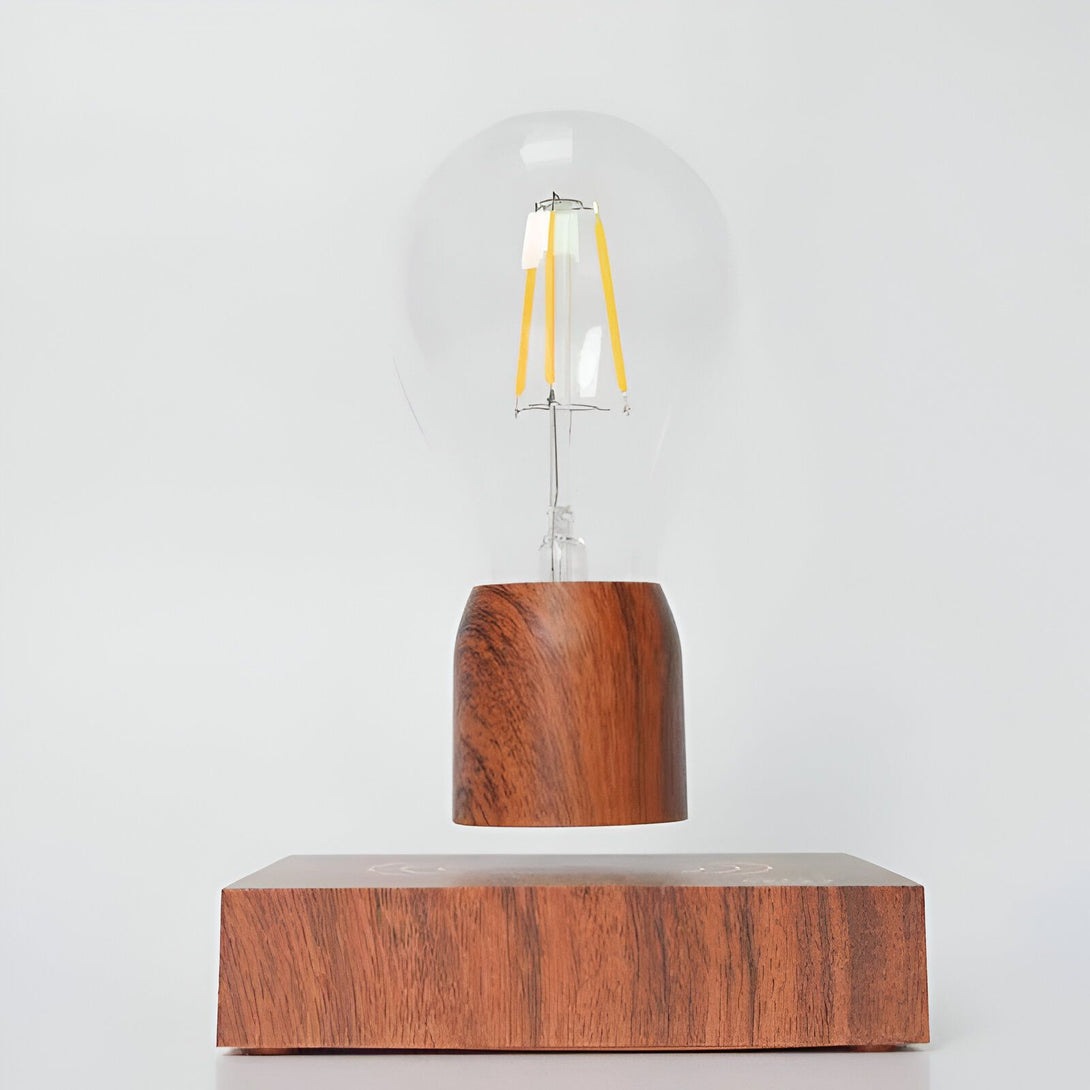 Une lampe de chevet en bois avec une ampoule qui flotte au-dessus d'un socle en bois. L'ampoule est éclairée et donne une lumière chaude. La lampe est moderne et élégante et s'intégrera parfaitement à votre intérieur. AL-5617346911,