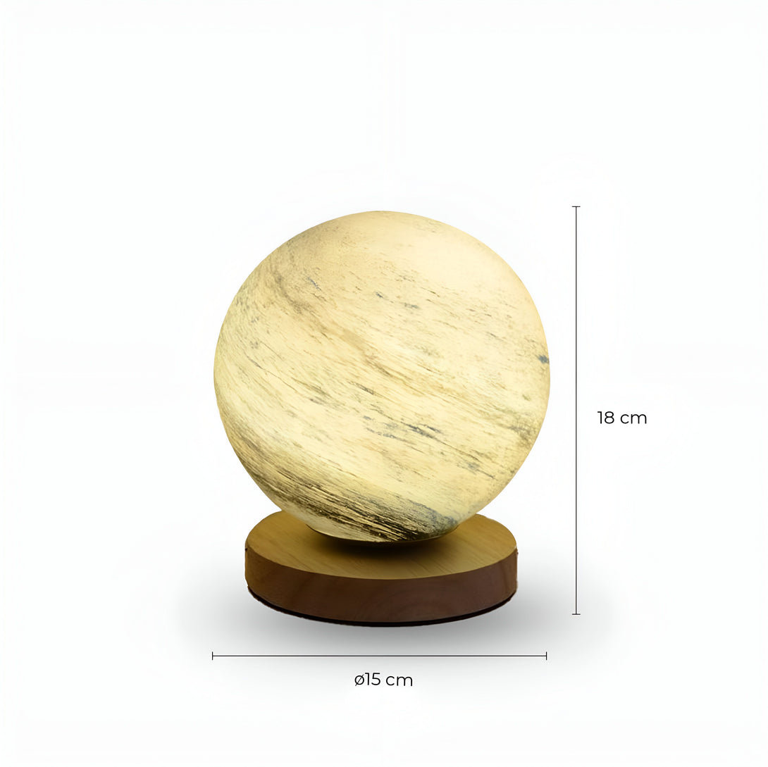 Une lampe sphérique en verre dépoli blanc est posée sur un socle en bois. La lampe est allumée et diffuse une lumière douce. OR-7630686498,OR-0614193508,