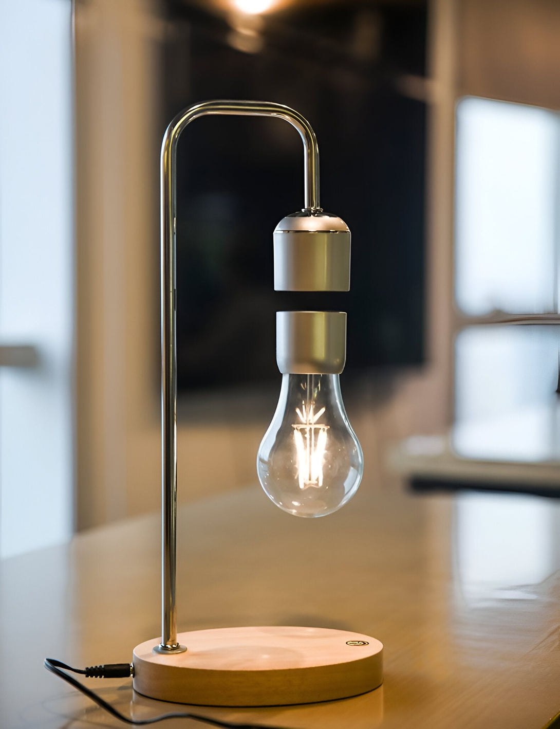 Une lampe à incandescence est suspendue au-dessus d'un socle en bois. La lampe est maintenue en l'air par un champ magnétique. LE-5812217572,