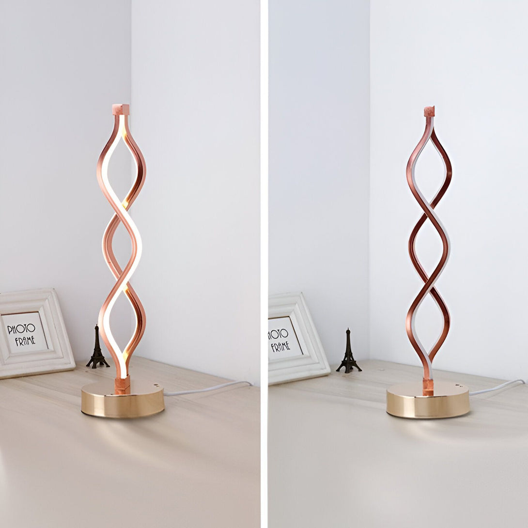 Une lampe de table en forme de spirale de couleur cuivre avec une base ronde et un interrupteur tactile. La lampe est allumée et émet une lumière blanche chaude. IN-761638868X,IN-2865725197,IN-8287419824,IN-8037118681,