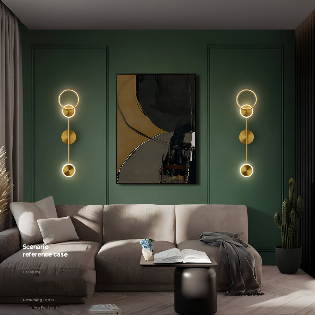 Une image d'un salon avec un canapé, une table basse, un tapis, une peinture et deux appliques murales. Les appliques murales sont en métal doré et ont un design moderne. Le salon est décoré dans un style contemporain avec des couleurs neutres et des meubles modernes. DO-3701537453,DO-1406931985,DO-774364684X,DO-8119607104,