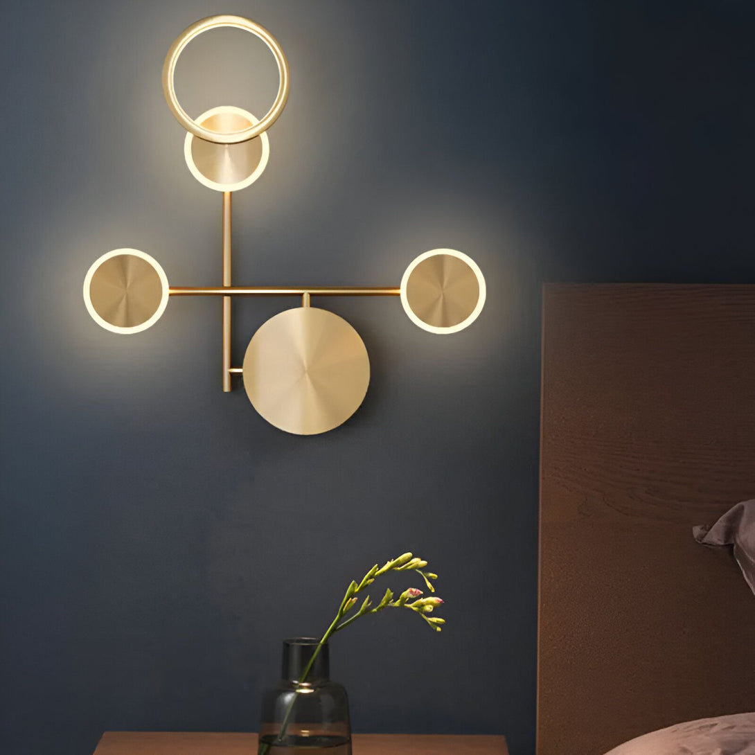 Une applique murale en métal doré avec quatre cercles lumineux. DO-3701537453,DO-1406931985,DO-774364684X,DO-8119607104,