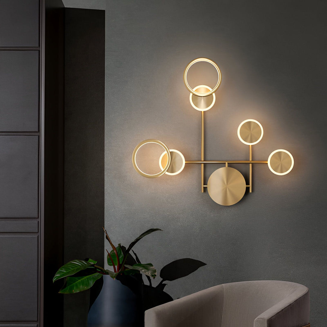 Une applique murale en métal doré avec cinq anneaux lumineux. DO-3701537453,DO-1406931985,DO-774364684X,DO-8119607104,